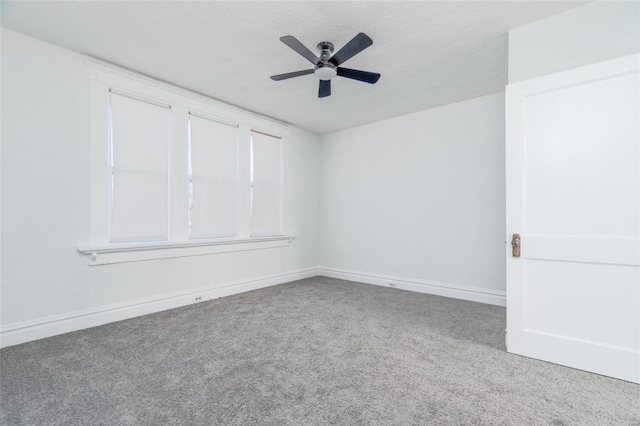 carpeted spare room with a textured ceiling, a ceiling fan, and baseboards