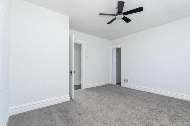 empty room with visible vents, baseboards, a ceiling fan, a textured ceiling, and carpet flooring