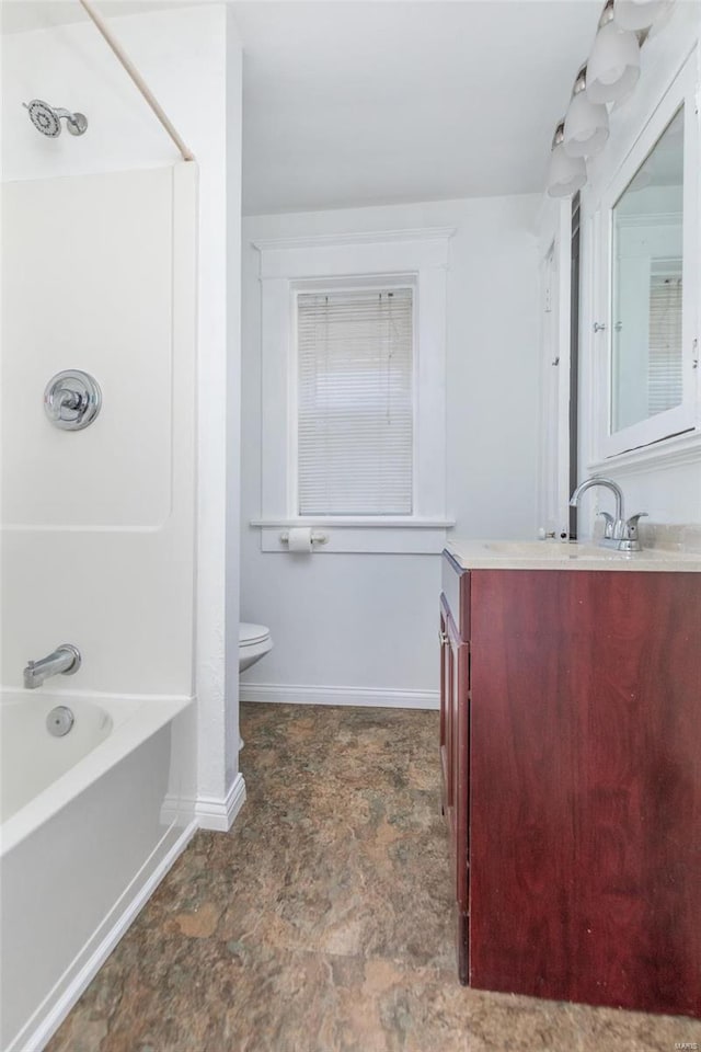 full bath with tub / shower combination, vanity, toilet, and baseboards