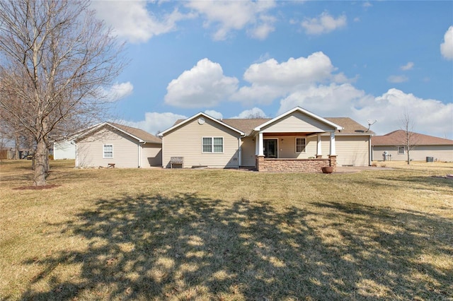 rear view of property with covered porch and a yard