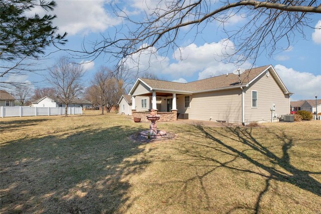 view of front of house featuring central AC, a front lawn, and fence