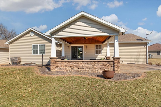 rear view of house with ceiling fan, a patio, and a lawn