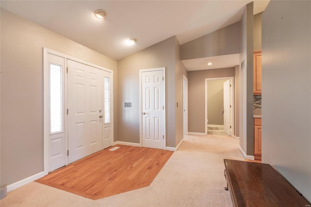 entrance foyer featuring light wood-type flooring, lofted ceiling, baseboards, and recessed lighting