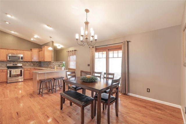 dining room featuring lofted ceiling, light wood-type flooring, an inviting chandelier, and baseboards