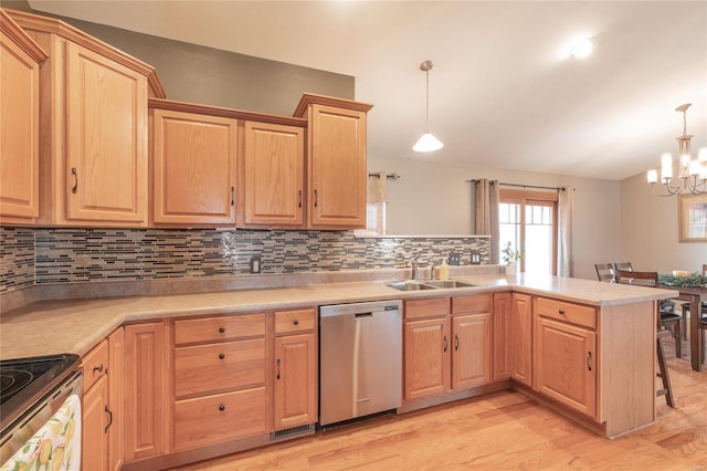 kitchen with appliances with stainless steel finishes, a peninsula, light countertops, light brown cabinetry, and a sink