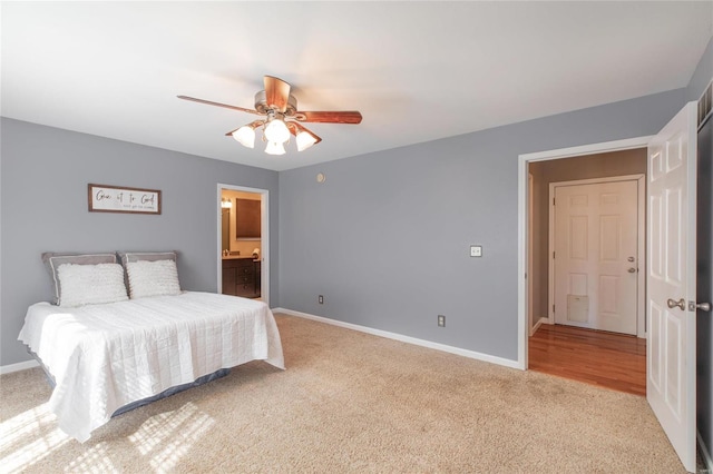 carpeted bedroom with ensuite bathroom, a ceiling fan, and baseboards