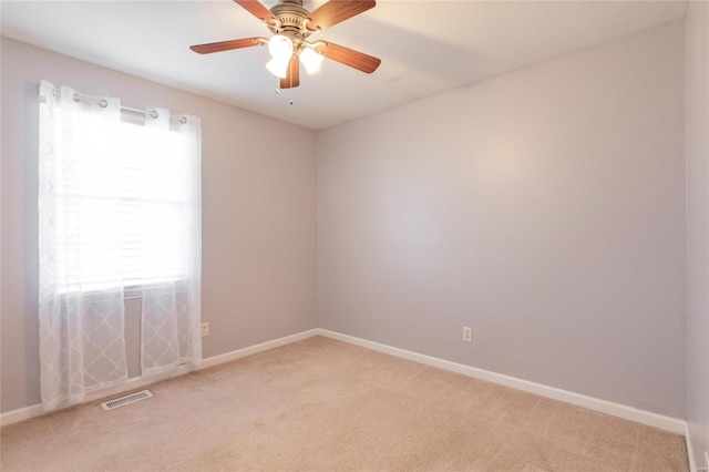 spare room with light carpet, plenty of natural light, and visible vents