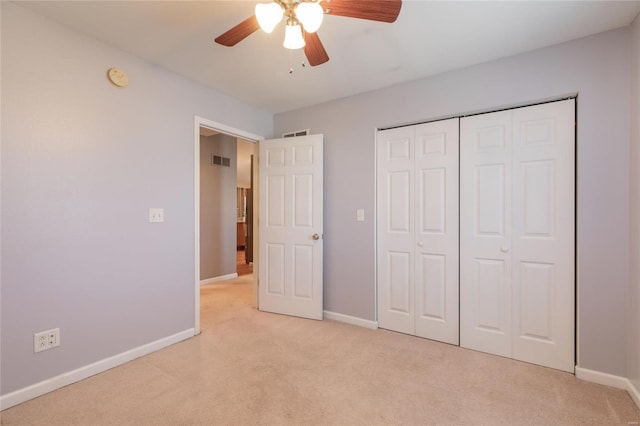 unfurnished bedroom with a closet, light colored carpet, visible vents, and baseboards