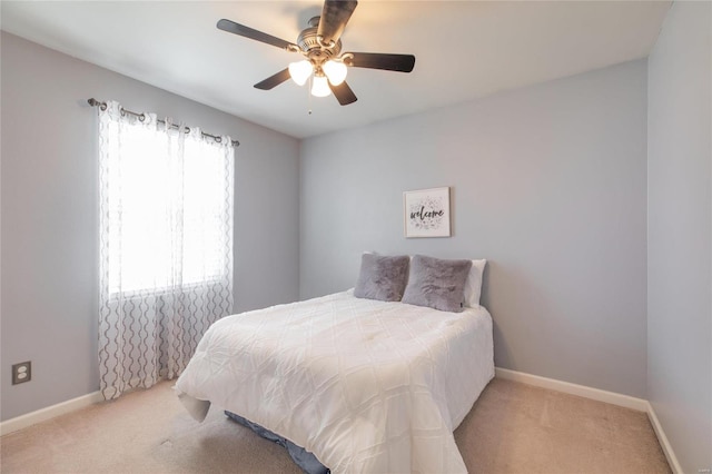 carpeted bedroom with a ceiling fan and baseboards