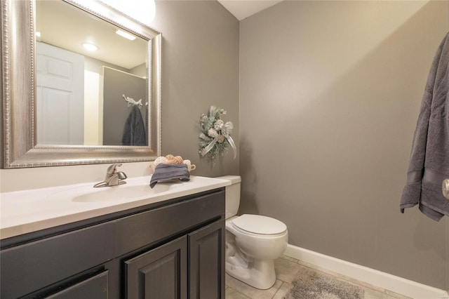 bathroom featuring tile patterned flooring, vanity, toilet, and baseboards