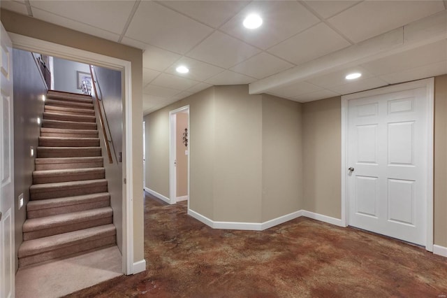 finished basement featuring stairs, baseboards, a drop ceiling, and recessed lighting