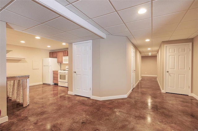 interior space featuring concrete floors, recessed lighting, a paneled ceiling, and baseboards