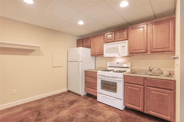 kitchen featuring white appliances, a sink, a paneled ceiling, and baseboards