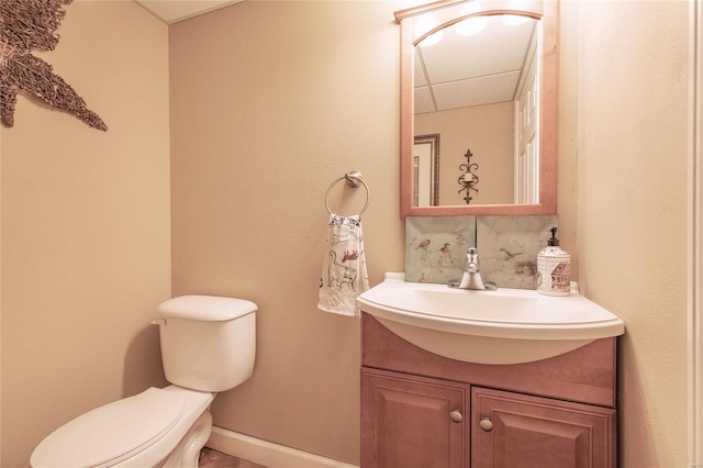 bathroom with toilet, tasteful backsplash, vanity, and baseboards