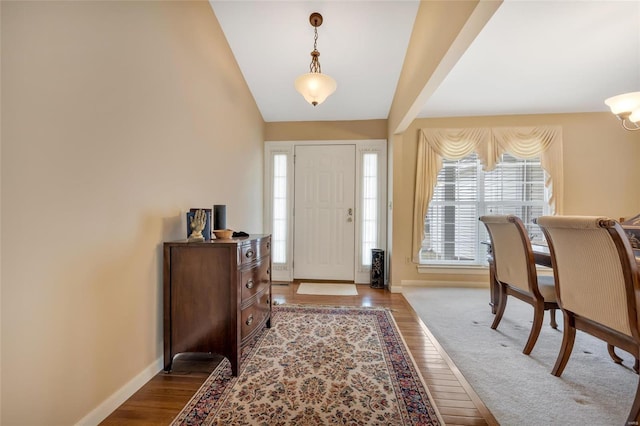 entryway featuring vaulted ceiling, baseboards, and wood finished floors