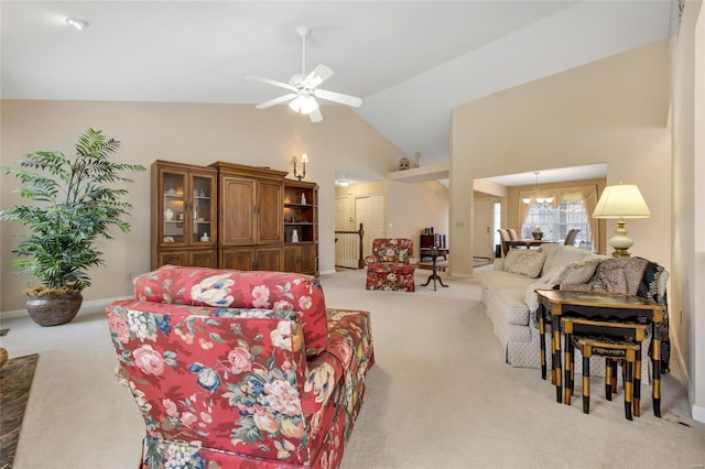 living room featuring light carpet, baseboards, high vaulted ceiling, and a ceiling fan