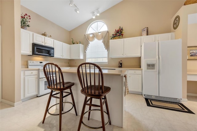 kitchen with white appliances, vaulted ceiling, white cabinets, and a center island