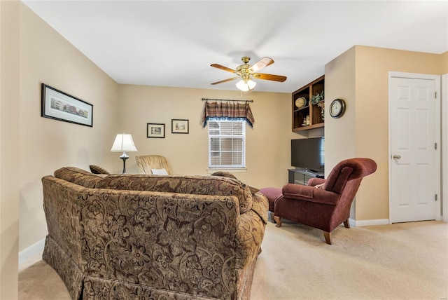 living room with a ceiling fan, light carpet, and baseboards