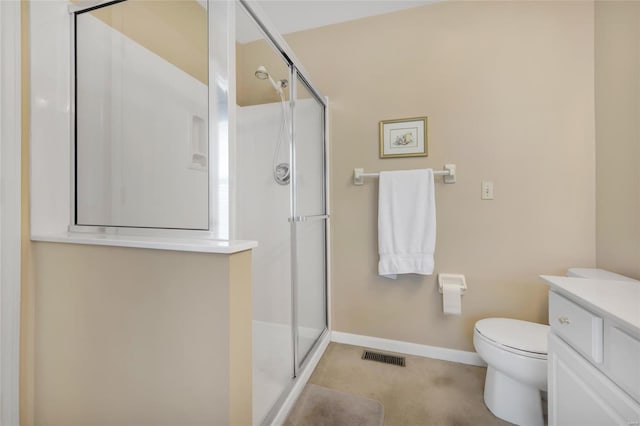 bathroom featuring toilet, vanity, visible vents, baseboards, and a shower stall