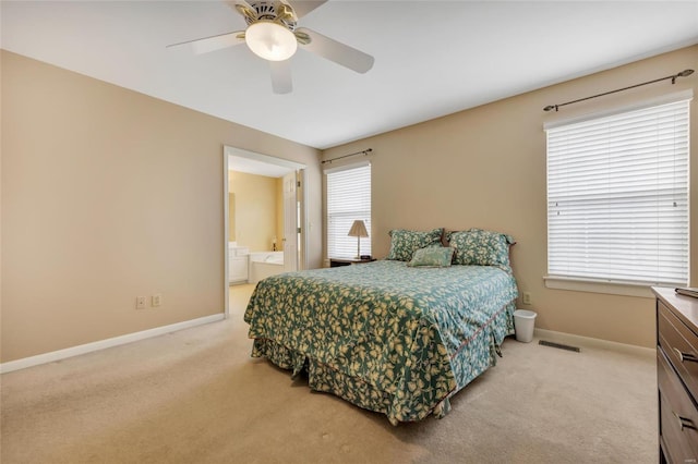 bedroom featuring ceiling fan, connected bathroom, light colored carpet, visible vents, and baseboards