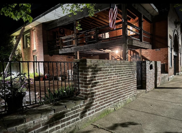 view of home's exterior with brick siding and fence