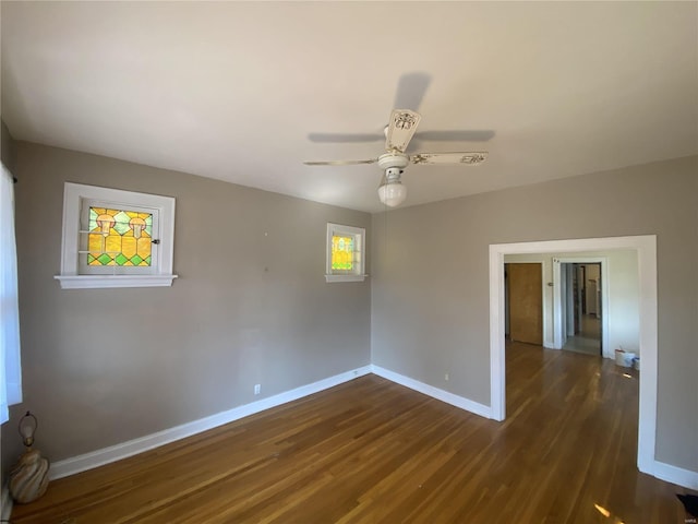 unfurnished room with dark wood-style floors, baseboards, and a ceiling fan