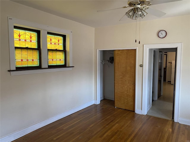 unfurnished bedroom with a closet, ceiling fan, baseboards, and wood finished floors