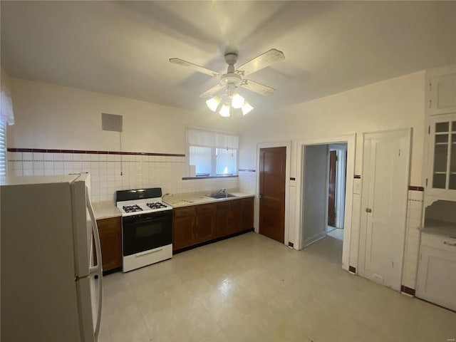 kitchen featuring white appliances, visible vents, a ceiling fan, light countertops, and a sink