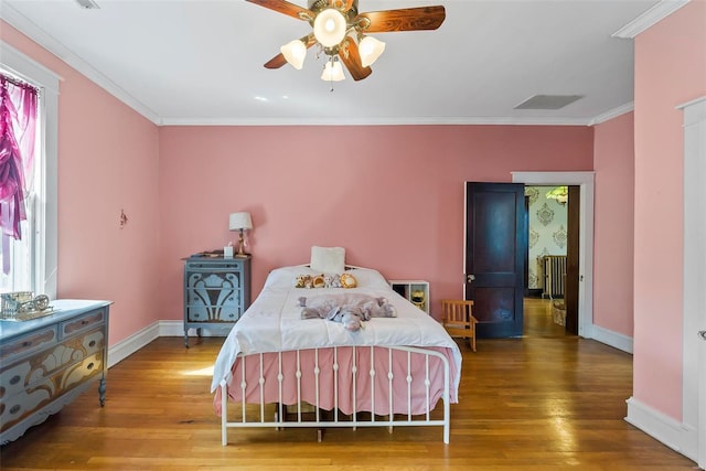 bedroom featuring radiator, ornamental molding, ceiling fan, wood finished floors, and baseboards