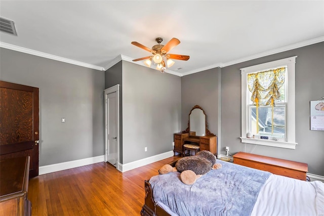 bedroom with visible vents, baseboards, ceiling fan, ornamental molding, and wood finished floors