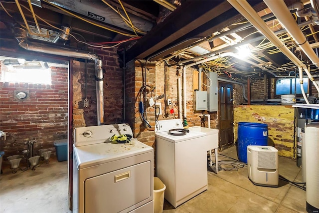 below grade area featuring brick wall and separate washer and dryer