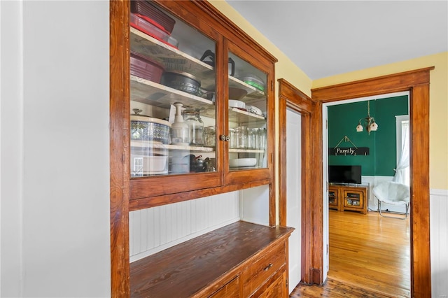 doorway to outside featuring wood finished floors and wainscoting