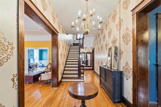 interior space featuring baseboards, ornamental molding, wood-type flooring, and wallpapered walls