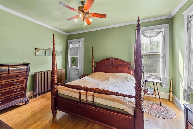 bedroom featuring ornamental molding, radiator, baseboards, and wood finished floors