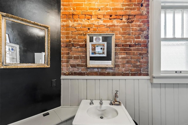 bathroom with a wainscoted wall and a sink