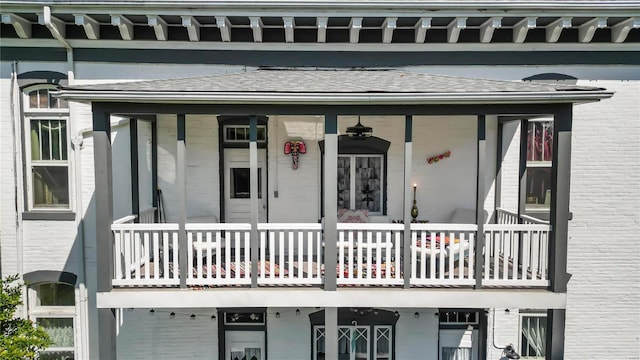 view of exterior entry featuring roof with shingles