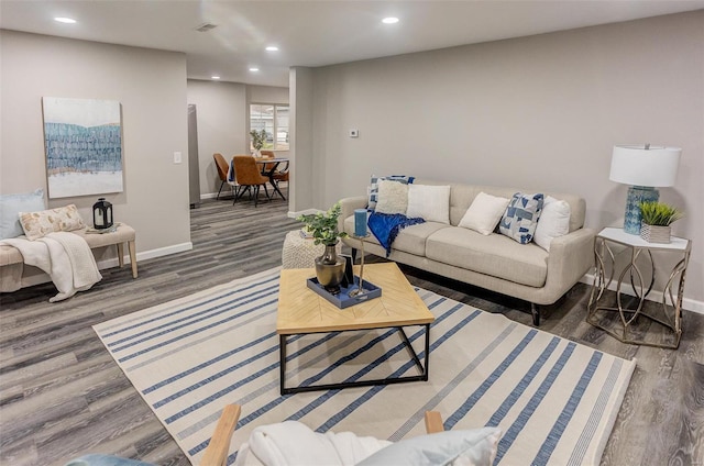 living room with visible vents, baseboards, wood finished floors, and recessed lighting