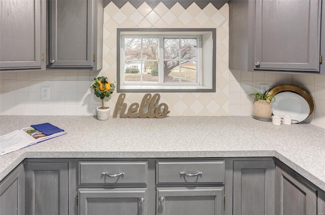 kitchen with light countertops, gray cabinets, and decorative backsplash