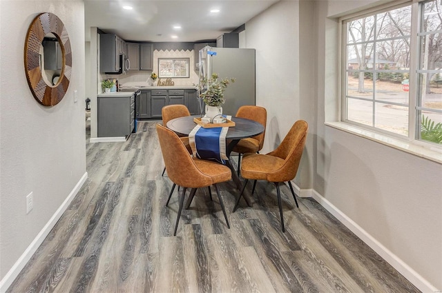 dining room featuring a wealth of natural light, recessed lighting, baseboards, and wood finished floors