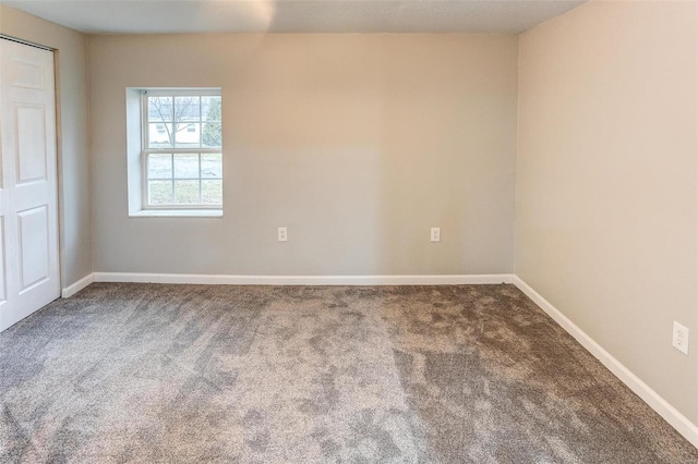 carpeted spare room featuring baseboards