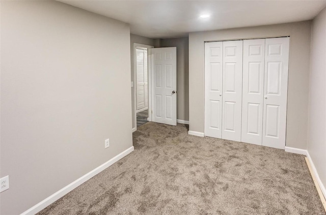 unfurnished bedroom featuring carpet, a closet, and baseboards