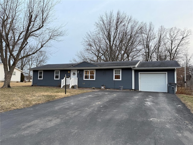 single story home featuring an attached garage and aphalt driveway