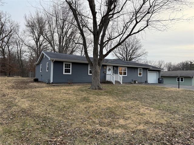 ranch-style home with a garage and a front lawn