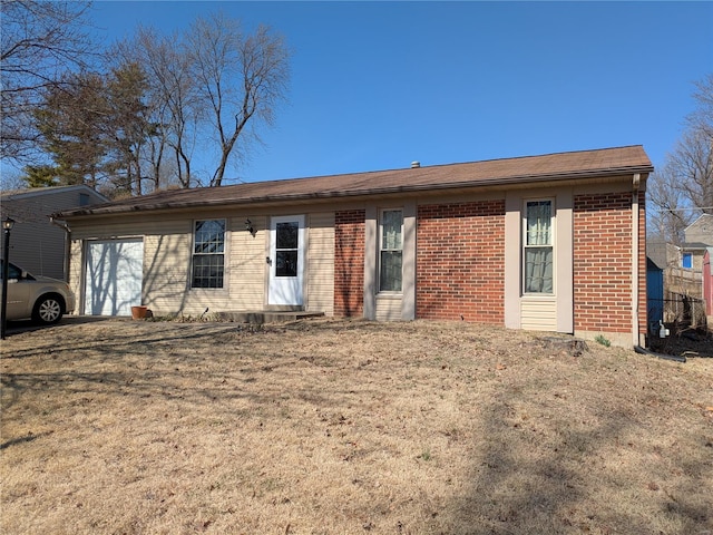 view of front of home with a garage, a front lawn, and brick siding