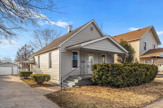 bungalow featuring an outbuilding, a porch, and a chimney