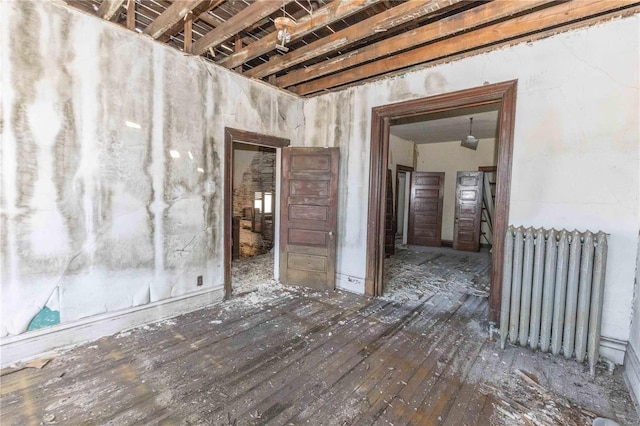 spare room with radiator heating unit and hardwood / wood-style flooring