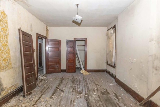 interior space with wood finished floors and baseboards