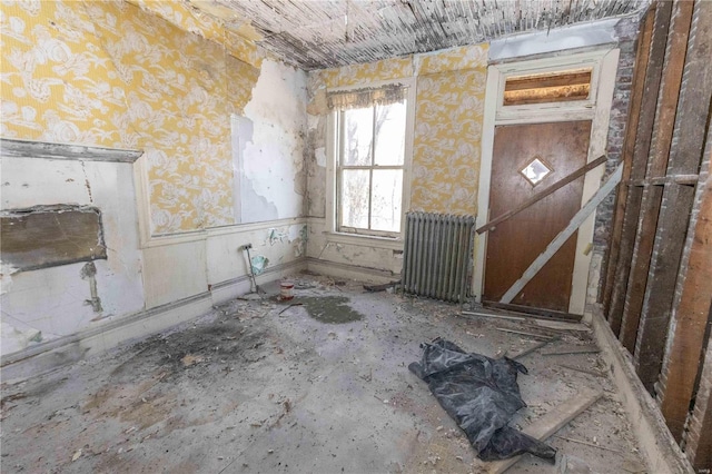 empty room featuring wallpapered walls and radiator