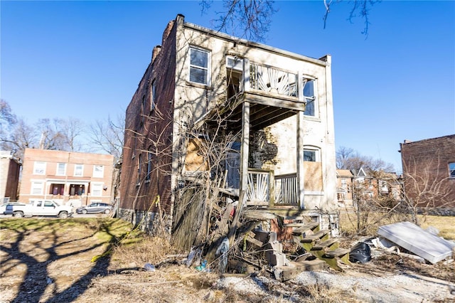 back of property featuring a chimney and a balcony