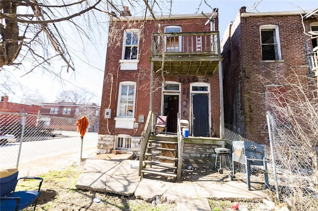 view of front facade featuring brick siding and fence